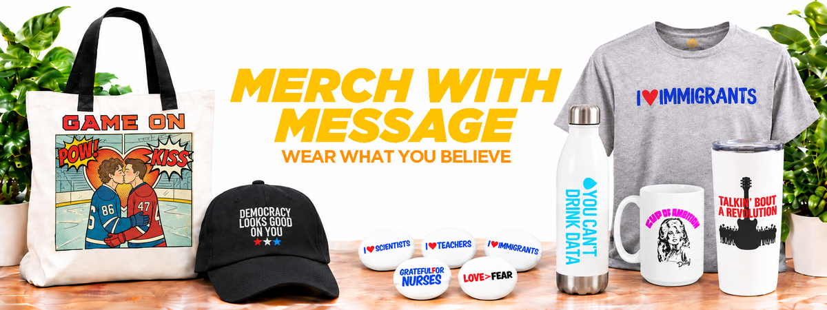 Text 'GAME ON', a black baseball cap reading 'DEMOCRATLY VOTING AGE 18 OR U R LATER', a gray T-shirt with 'I ❤️ IMMIGRANTS' in blue and red, a white insulated bottle labeled 'VIRGINIA DRINK CULT', a white mug with a black portrait and text, a white tumbler, several small white enamel pins, and large central text reading 'MERCH WITH MESSAGE WEAR WHAT YOU BELIEVE'. Plants are visible in the background.